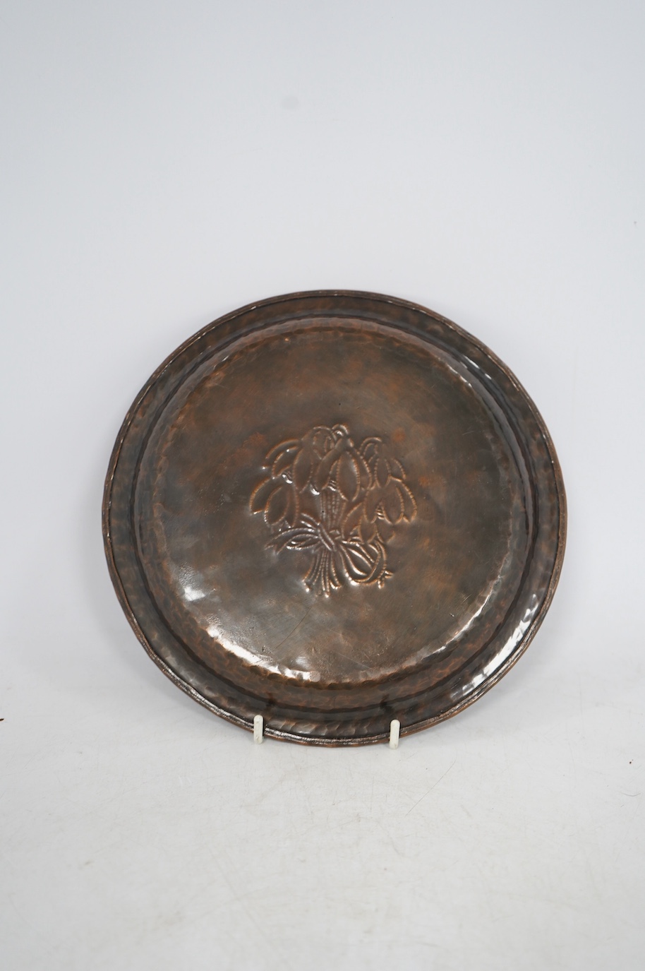 A Hugh Wallis Arts & Crafts small copper and pewter tray decorated with snowdrops, stamped HW, diameter 19.5cm. Condition - fair